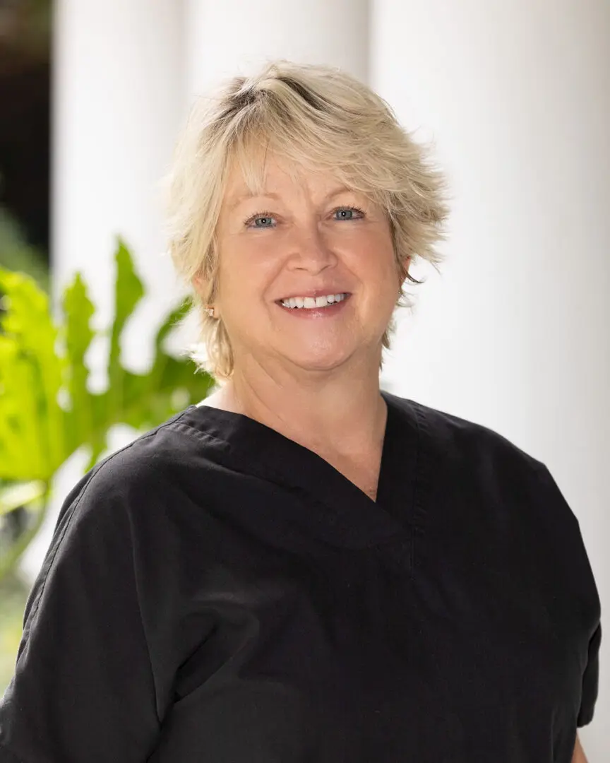 A woman in black shirt smiling for the camera.