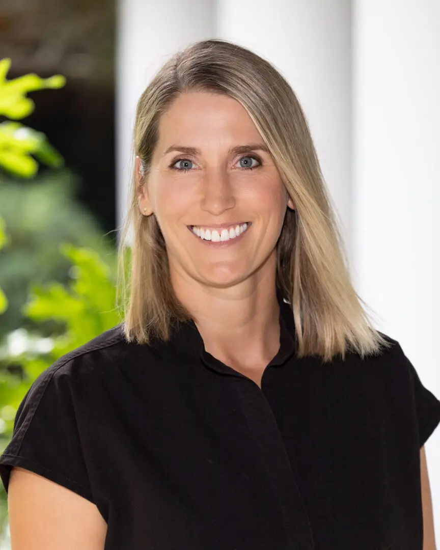 A woman in black shirt smiling for the camera.