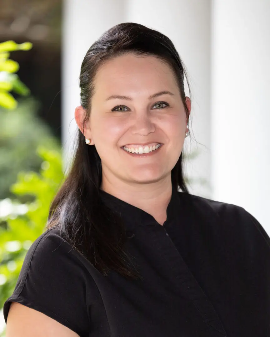 A woman in black shirt smiling for the camera.